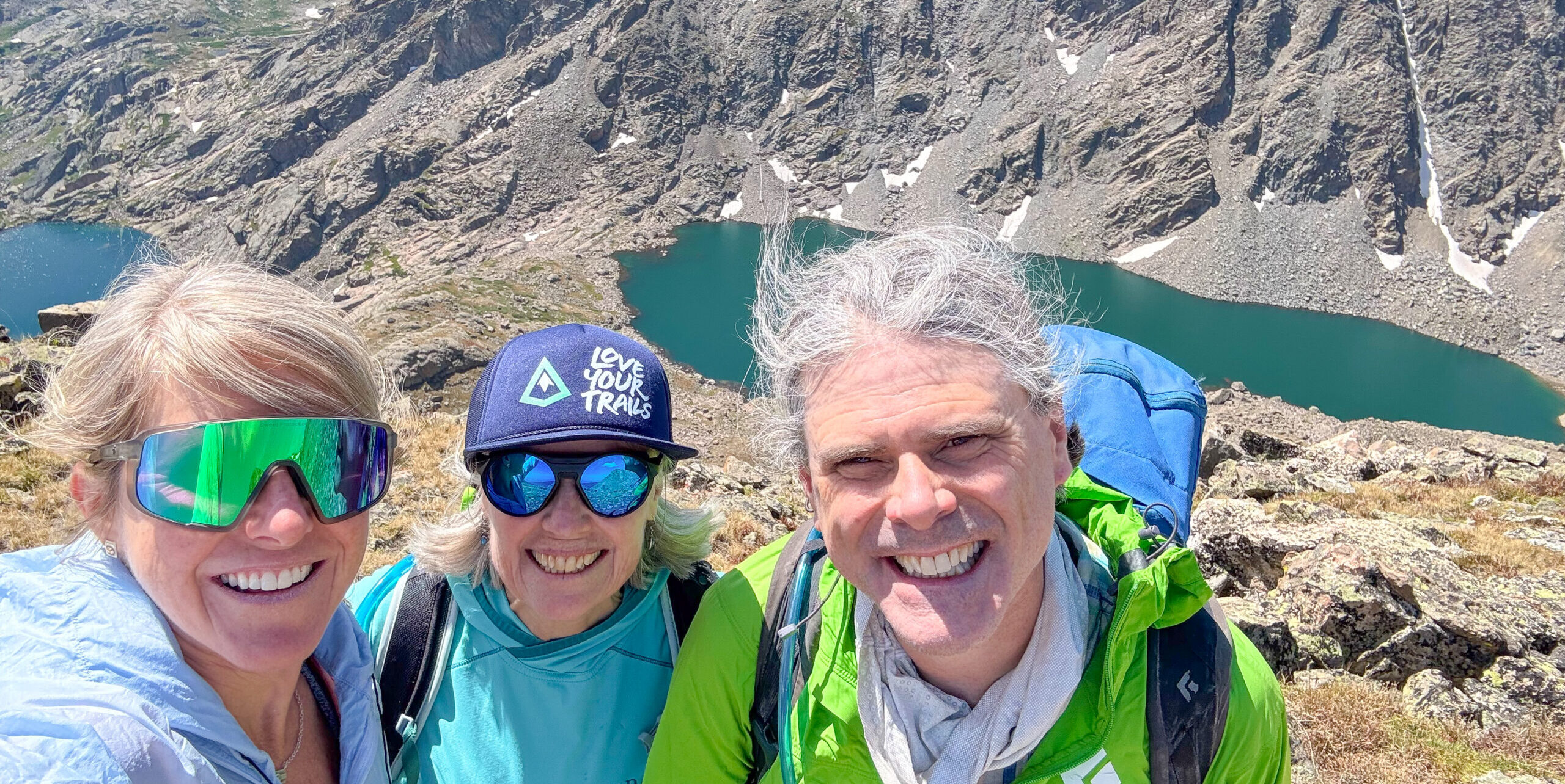 Hikers at the summit of Mount of the Holy Cross in the Eagles Nest Wilderness Vail Valley wearing a Love Your Trails hat