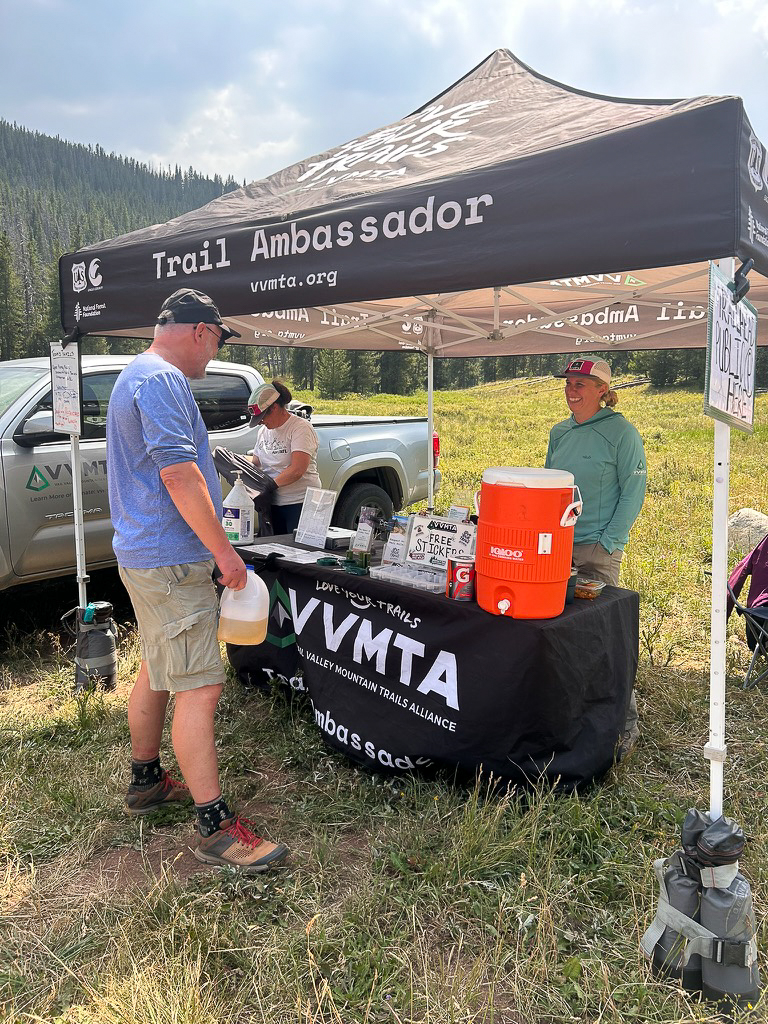 VVMTA Trail Ambassador discussing trail etiquette in Eagle County with a hiker at a summer Wilderness trailhead
