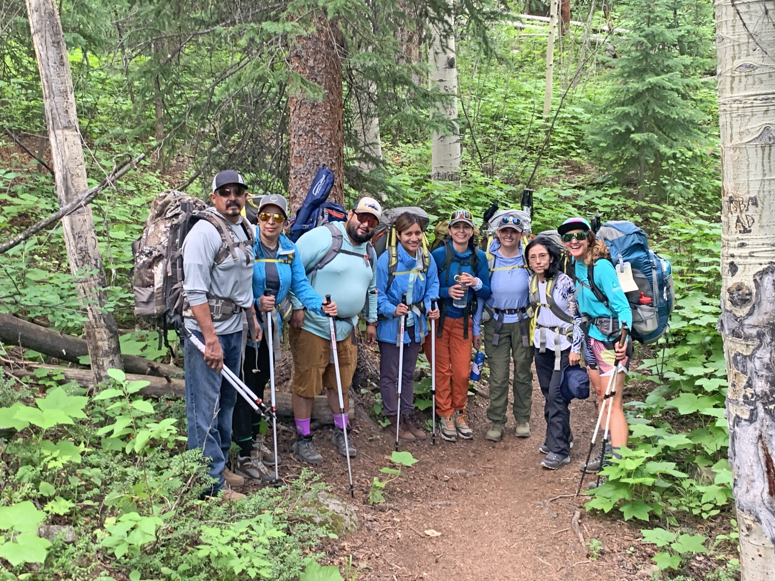 Group of Soul Dirt backpacking trip participants on trail with full packs