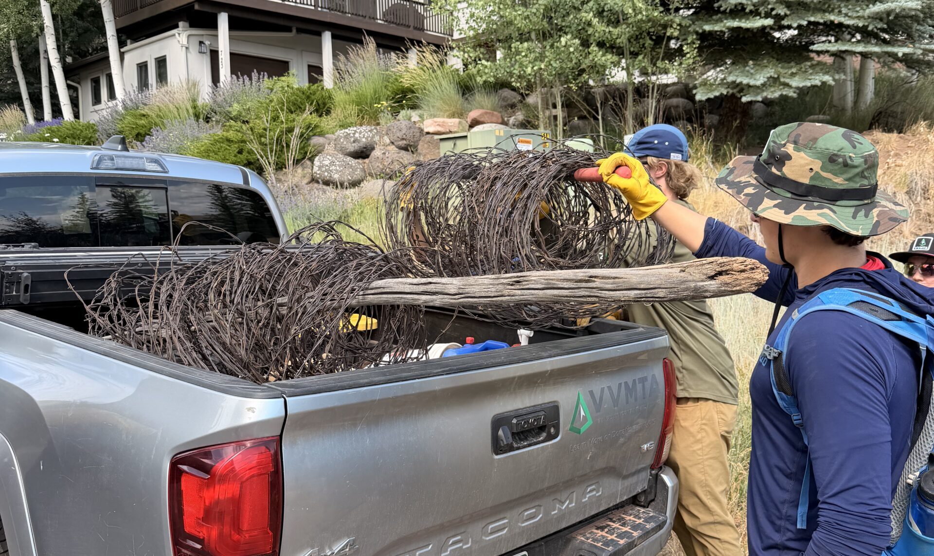 Eagle County Youth Corps crew loading removed barbed wire fencing into a truck bed