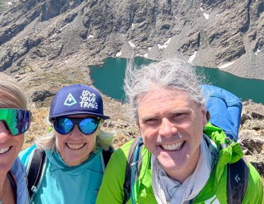 Hikers at the summit of Mount of the Holy Cross in the Eagles Nest Wilderness Vail Valley wearing a Love Your Trails hat